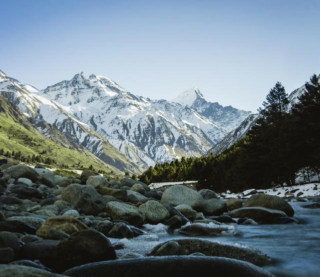 A scenic view of the snow-capped mountains and lush valleys of Himachal Pradesh, showcasing the natural beauty of the region. Perfect for Himachal Pradesh tour packages, this image highlights the best time to visit Himachal Pradesh, offering a glimpse into its breathtaking landscapes. The photo also hints at the rich cultural blend between Kerala and Himachal Pradesh, while featuring traditional Himachali food, a highlight of the local cuisine.